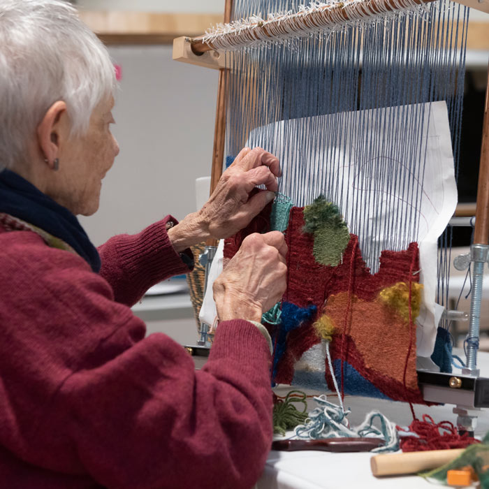 Weaving a tapestry in the Fiber Arts Studio