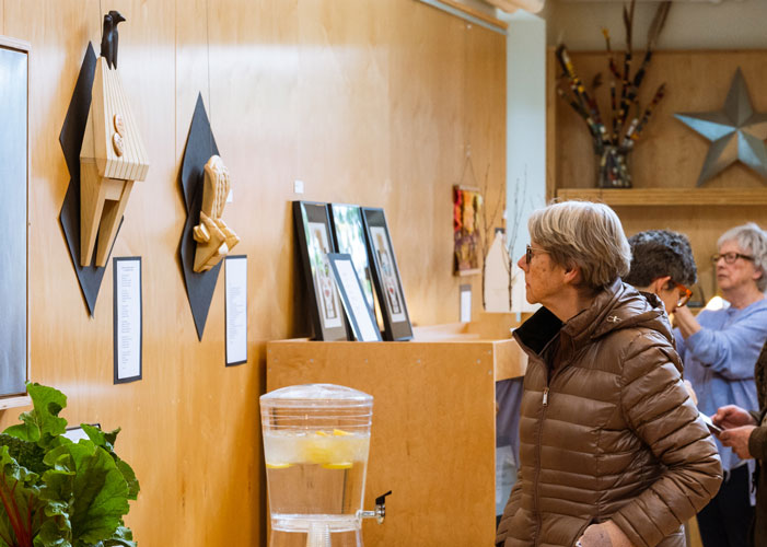 Exhibit attendee looking at artwork in BARN Commons