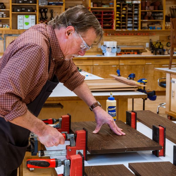 Woodworker gluing boards together