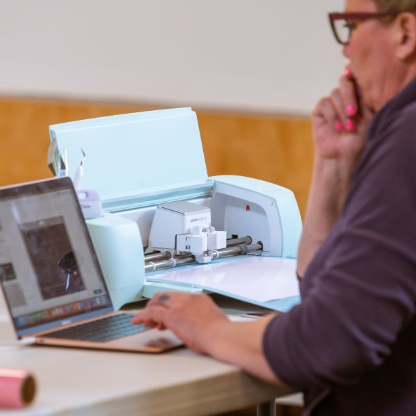 Student learning to use the Cricut in the Tech Lab