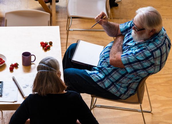 Michael Gunderson talks with another person at a community drawing meetup.