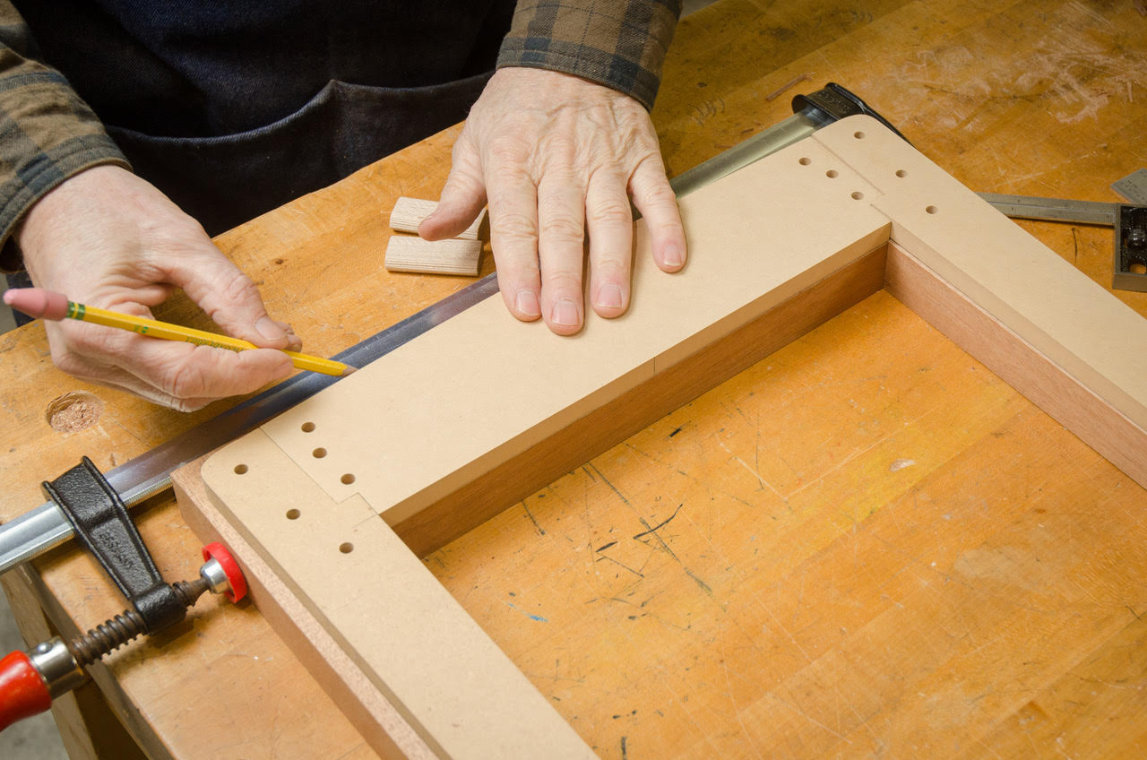 closeup of woodworker building mirror frame