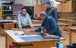 Woodworkers at work on library bench community service project.